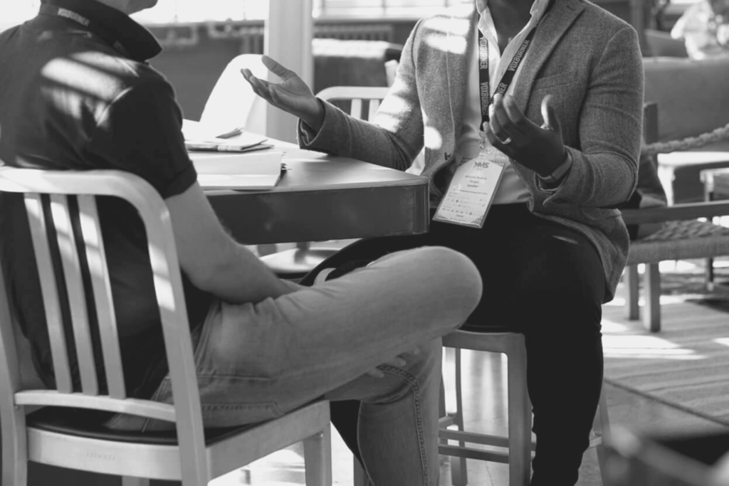 Deux personnes sont assises autour d'une table et discutent