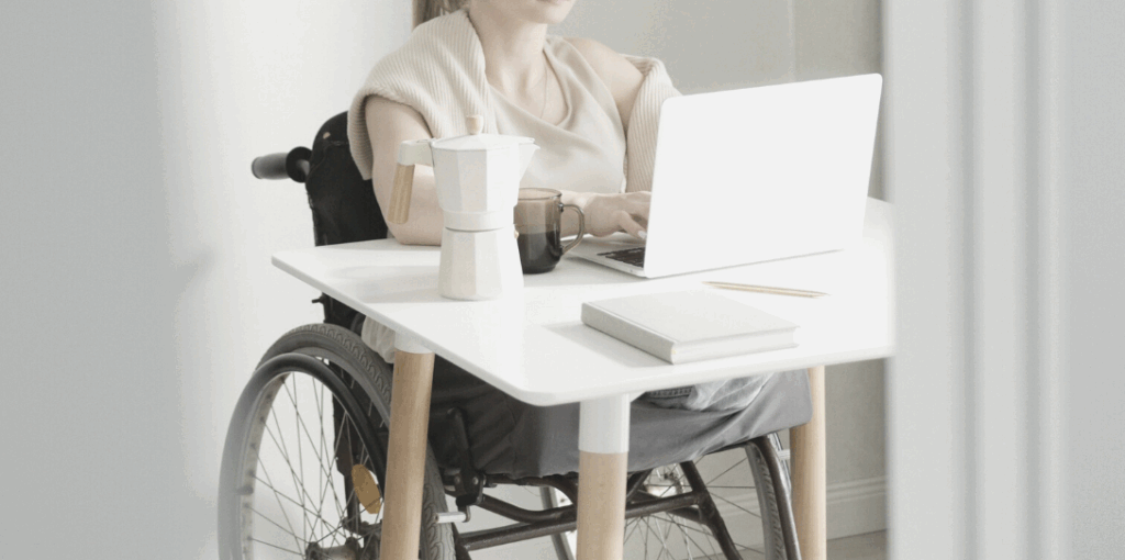photo d'une personne en fauteuil roulant travaillant sur un ordinateur