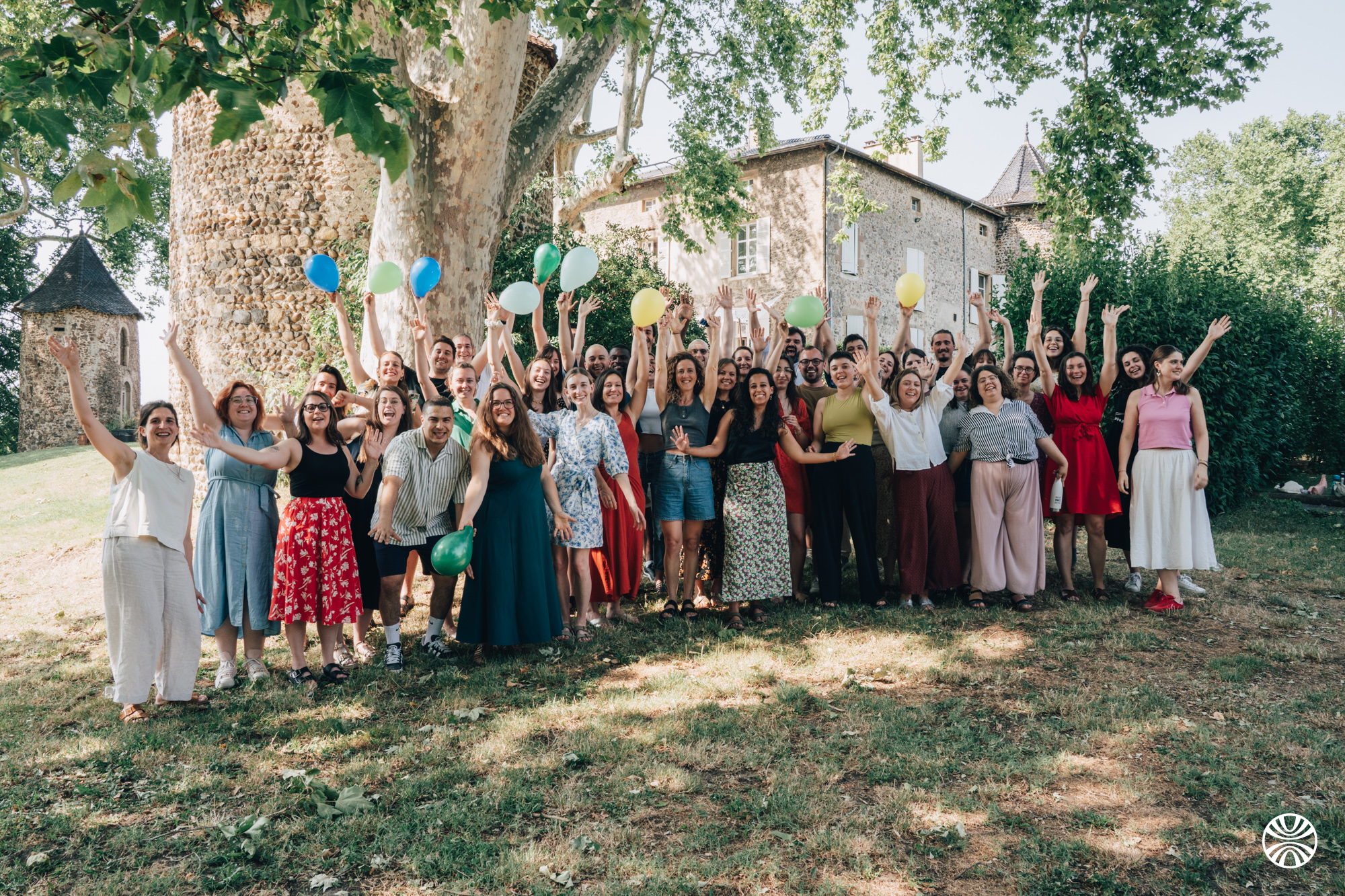 L’équipe Linklusion, joyeuse, dans un espace vert, les mains levées et tenant des ballons de différentes couleurs.