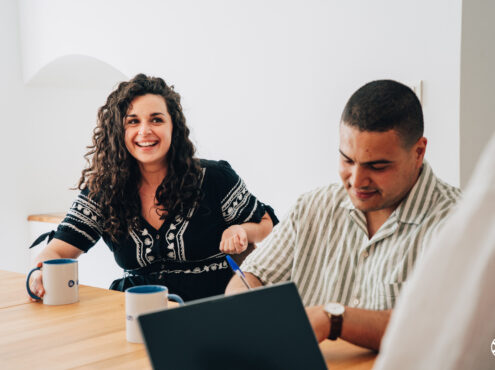 Photo de 2 collègues souriants en train de travailler.