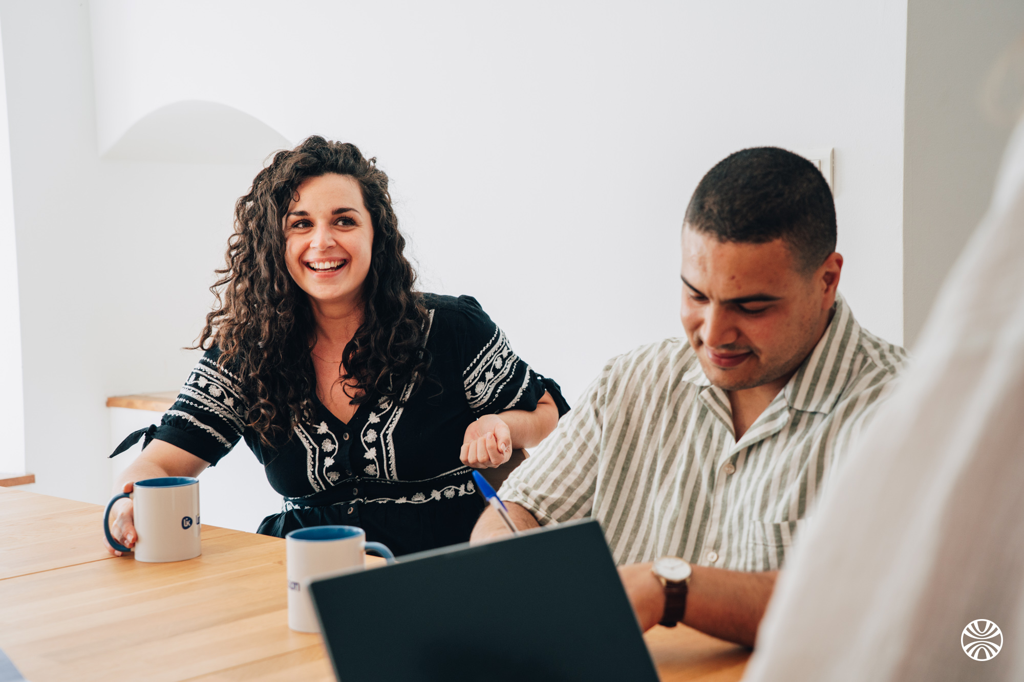 Photo de 2 collègues souriants en train de travailler.