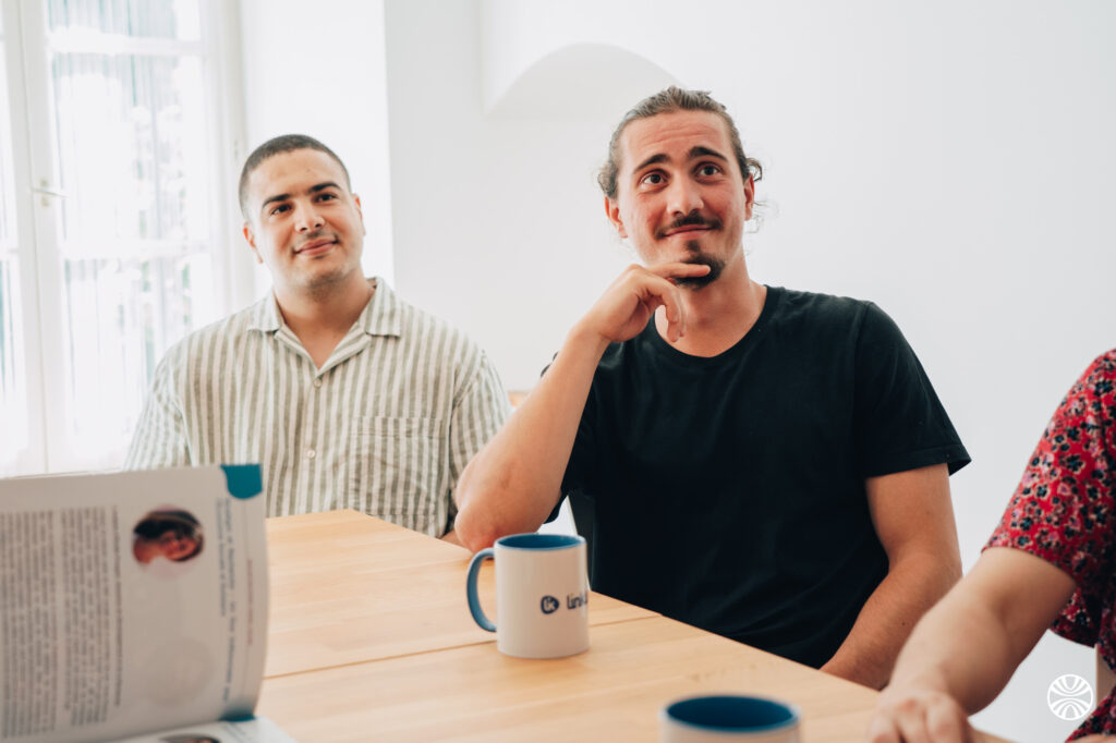 deux hommes asis à un bureau avec une tasse de linklusion