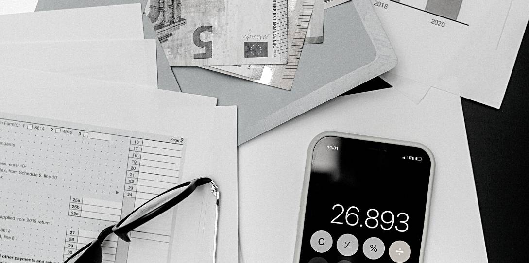 photo noir et blanc calculette et documents de travail